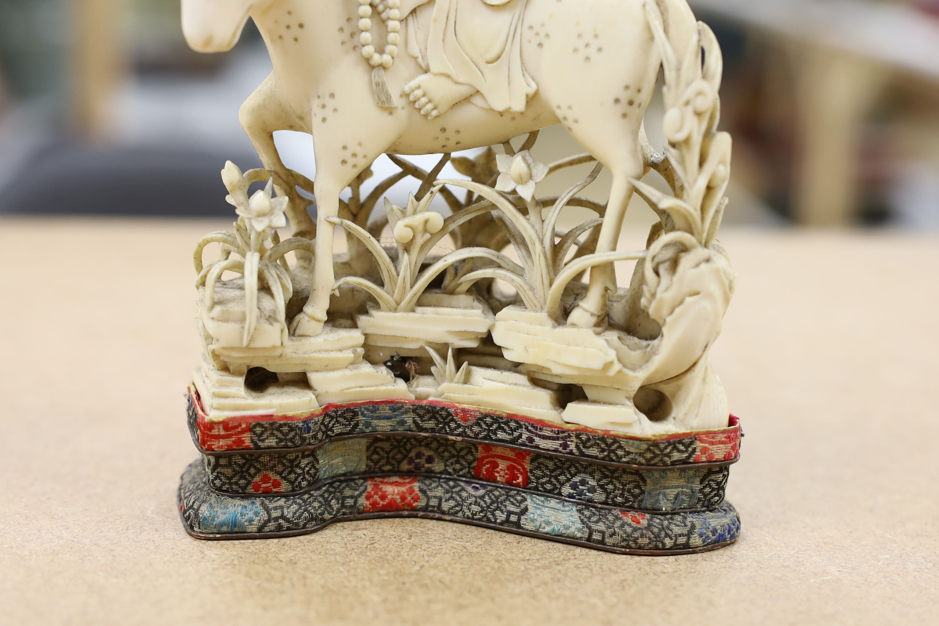 A Chinese carved ivory figure of a female immortal riding a deer, early 20th century, height 17cm excl. stand